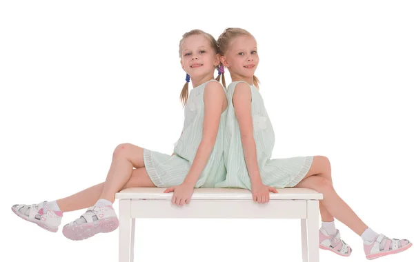 Hermanas lindas divirtiéndose sentado en una silla . —  Fotos de Stock