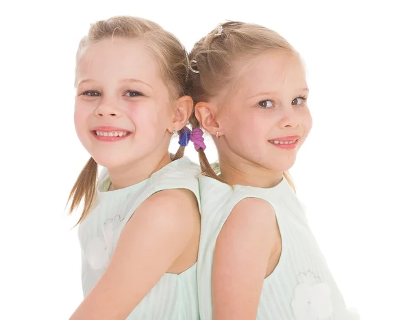 Cute sisters having fun sitting on a chair. — Stock Photo, Image