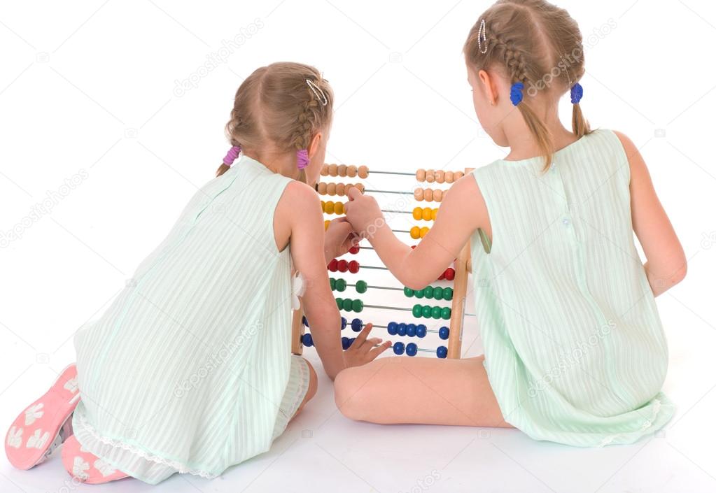 Cute sisters work in the Montessori environment.