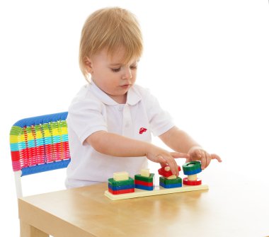 heyecanla montessori malzeme ile çalışan küçük bir çocuk