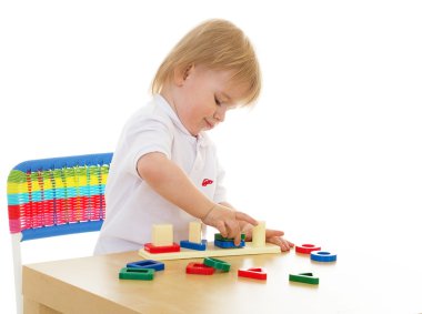 heyecanla montessori malzeme ile çalışan küçük bir çocuk