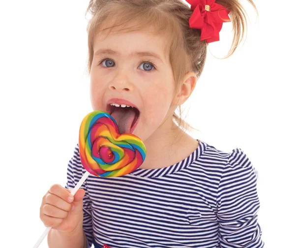 Klein meisje likken een lolly. — Stockfoto