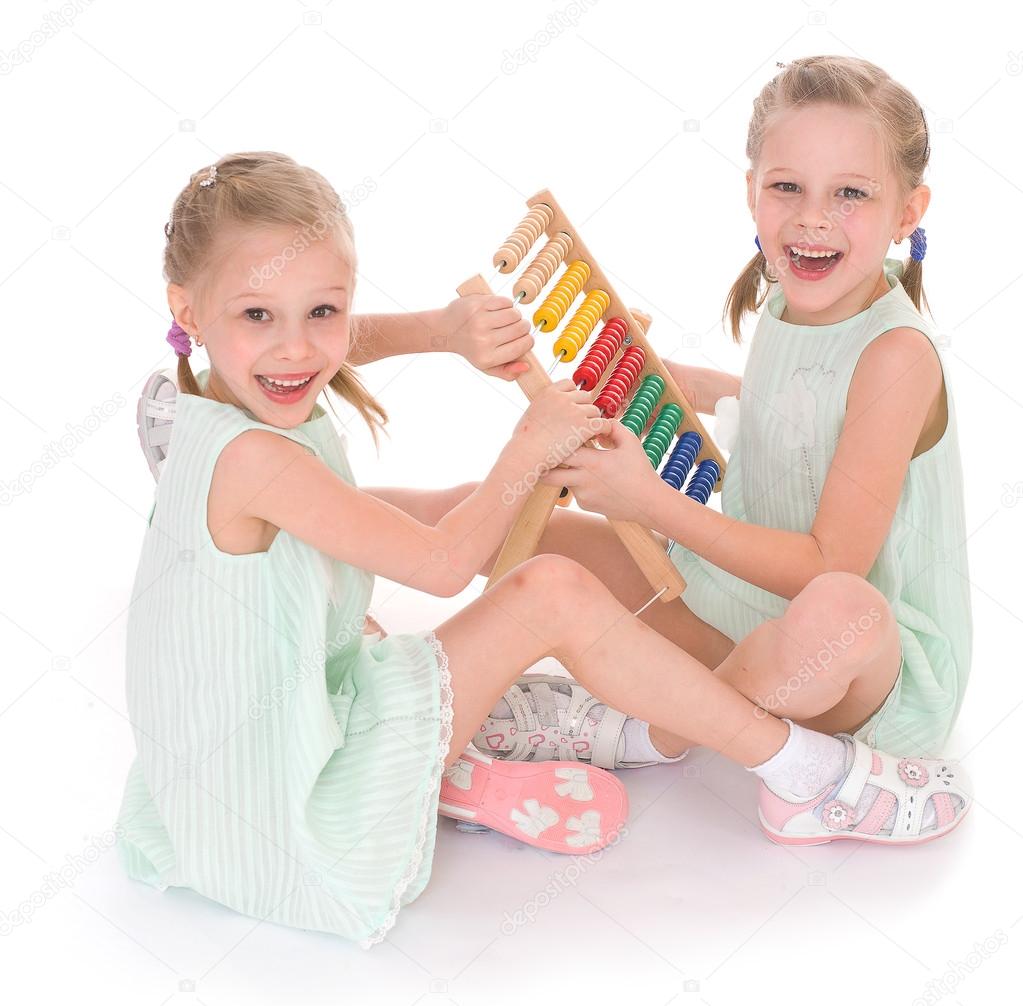 Cute sisters work in the Montessori environment.