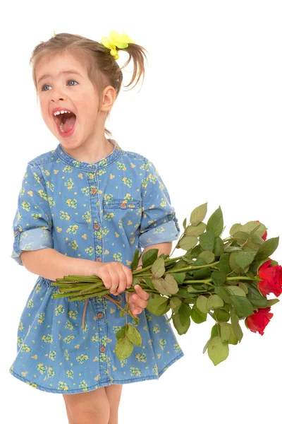 Charmante petite fille tenant un bouquet de roses rouges . — Photo