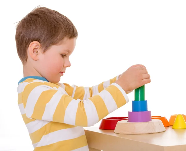 Pequeño niño juega con una pirámide — Foto de Stock