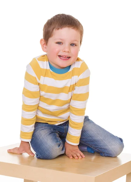 O menino está sentado na mesa. . — Fotografia de Stock