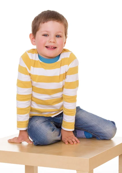 Kleiner Junge sitzt auf dem Tisch. — Stockfoto