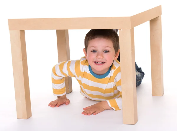 Mały chłopiec siedzi na stole. — Zdjęcie stockowe