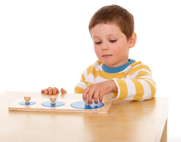 Kleiner Junge spielt am Tisch — Stockfoto