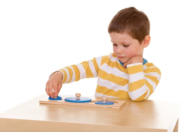Mały chłopiec bawi się przy stole — Zdjęcie stockowe