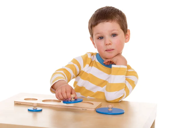 Маленький мальчик играет за столом — стоковое фото