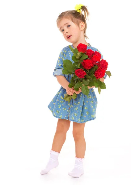 Charmantes kleines Mädchen mit einem Strauß roter Rosen. — Stockfoto