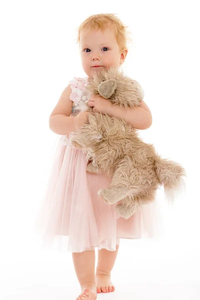 Mooi klein meisje met een speelgoed hond. — Stockfoto
