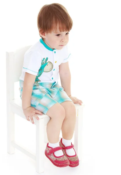 Kleine jongen zittend op een stoel. — Stockfoto