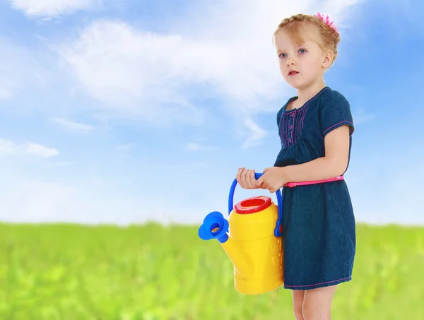 Igirl with a yellow watering can — Stock Photo, Image