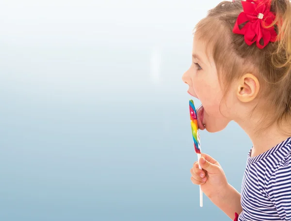 Little girl licking a lollipop — Stock Photo, Image