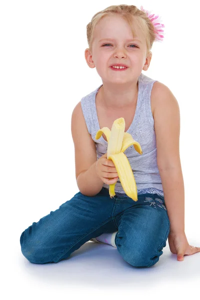 Little girl eating a juicy banana — Stock Photo, Image