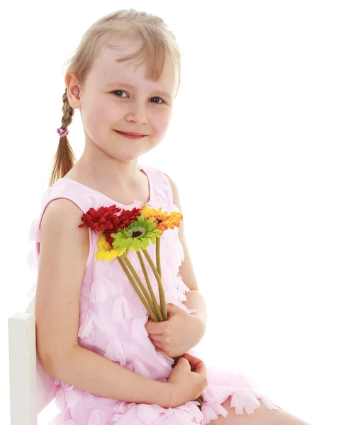 Young girl sitting with a bunch of flowers. — Stock Photo, Image