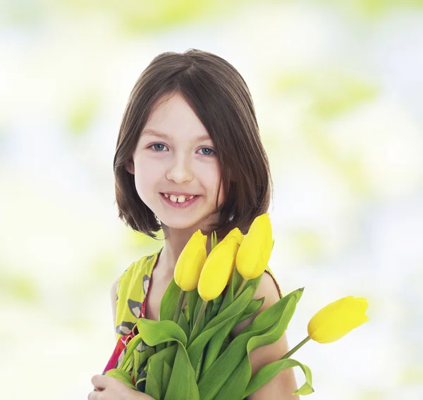 Meisje met gele tulpen — Stockfoto
