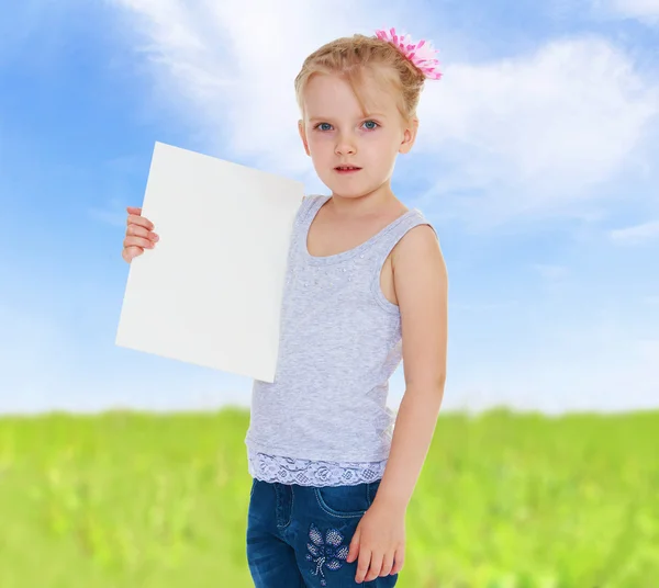 Mädchen hält ein Blatt Papier in der Hand. — Stockfoto