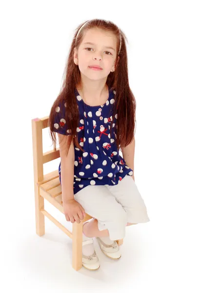 Girl sitting on a small chair. — Stock Photo, Image