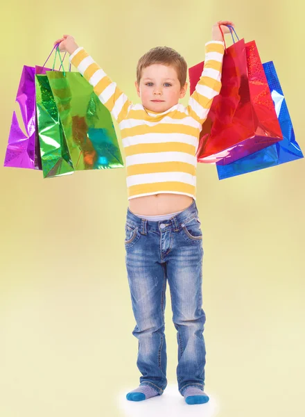 Little boy in colorful bags goes to the store. — Stock Photo, Image