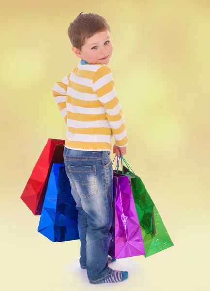 Küçük oğlan renkli çantalar da markete gider. — Stok fotoğraf