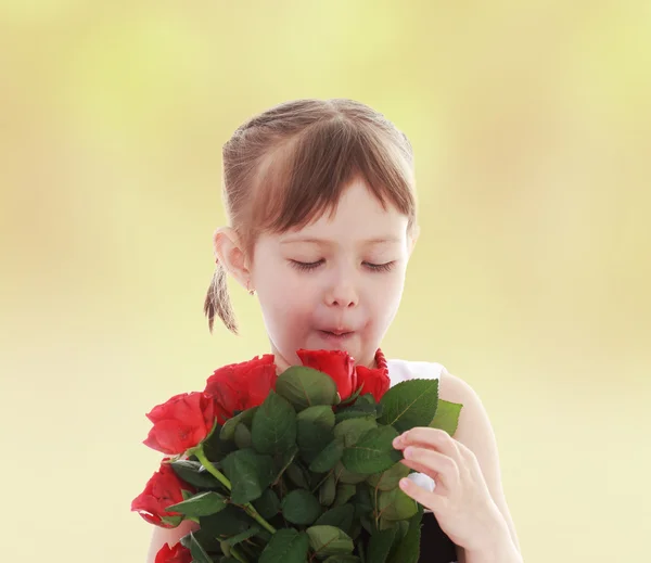 Menina considera um buquê de rosas . — Fotografia de Stock