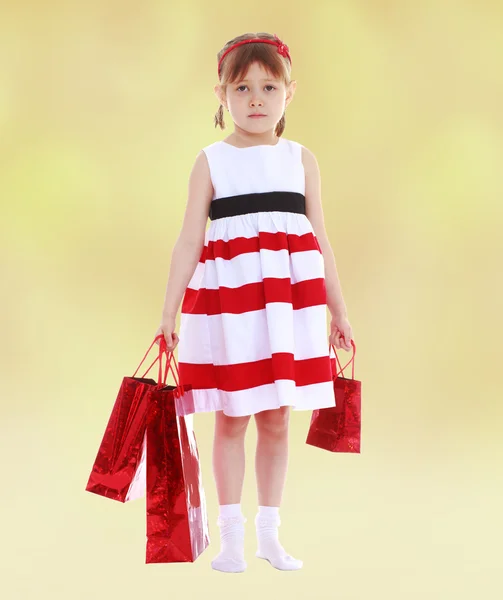 Girl with red packets is shop. — Stock Photo, Image