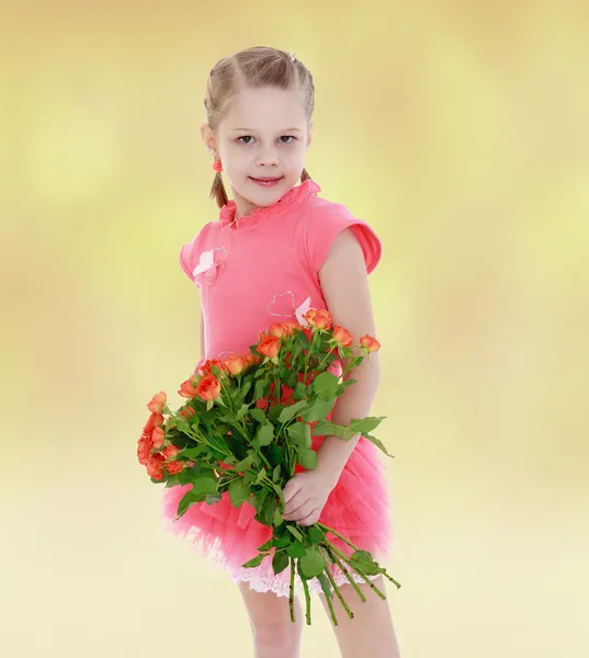 Menina bonito em um vestido rosa com um buquê de rosas — Fotografia de Stock