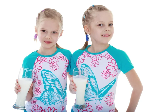 Two sisters with glasses of milk — Stock Photo, Image