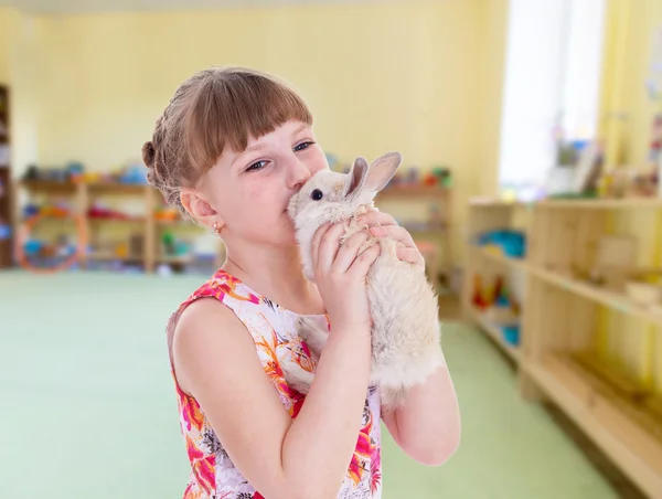Tjej kysser en sällskapsdjur kanin. — Stockfoto