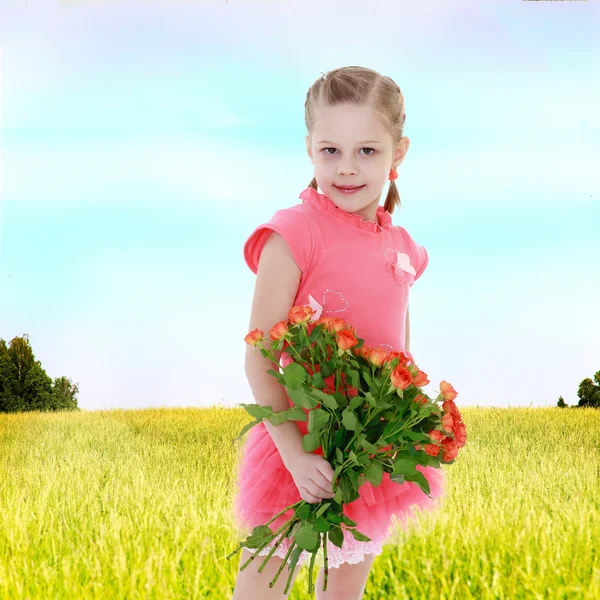 Девушка в поле с букетом цветов . — стоковое фото