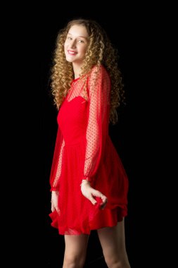 Mutlu gülümseyen sarışın kız elbisesini kaldırıyor.