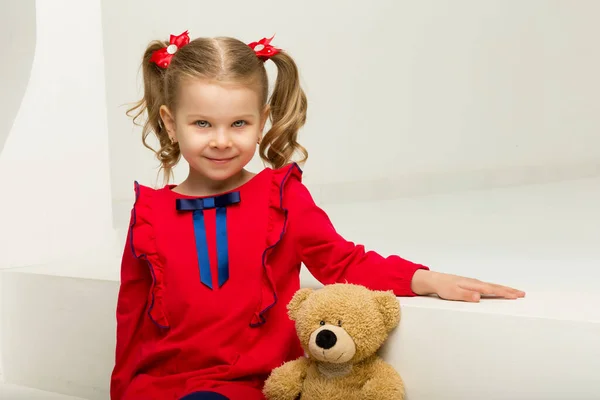 Little girl sitting on stairs with teddy bear — Stock Photo, Image