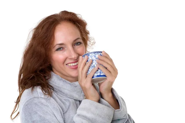 Mujer sonriente sosteniendo taza de porcelana — Foto de Stock