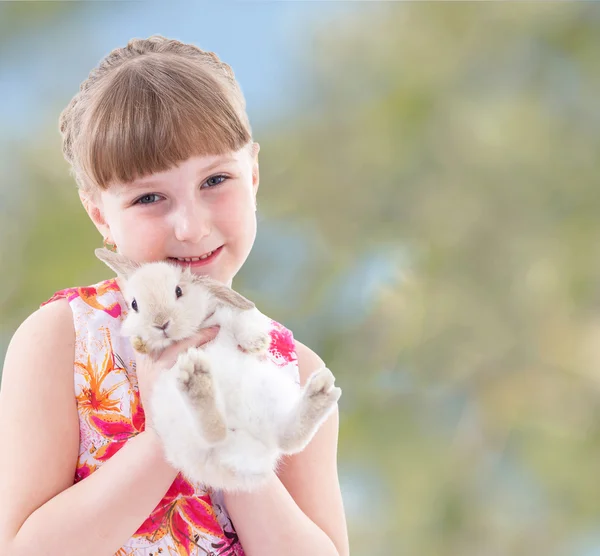Śmiejąca się dziewczyna trzyma pewien królik. — Zdjęcie stockowe