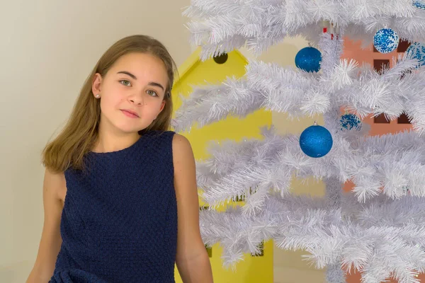 スタイリッシュなドレスの女の子クリスマスツリーの前の床に座って. — ストック写真