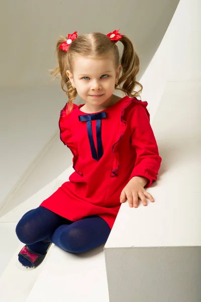 Nettes blondes kleines Mädchen sitzt auf der Treppe — Stockfoto