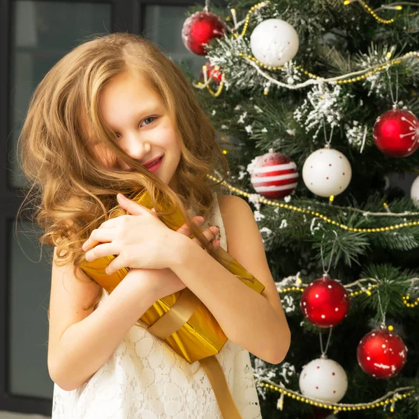 Tiener meisje in mooie witte jurk poseren in kerstmis interieur. — Stockfoto