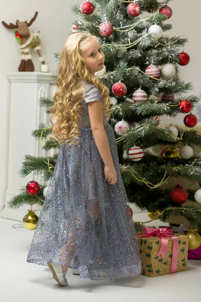 Şık Elbiseli Kız Noel ağacının önünde yerde oturuyor.. — Stok fotoğraf