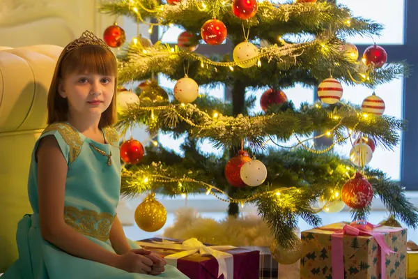 Menina bonita sorrindo com presente perto da árvore de Natal — Fotografia de Stock