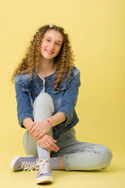 Glückliches Mädchen sitzt auf dem Boden und umarmt ihr Knie — Stockfoto