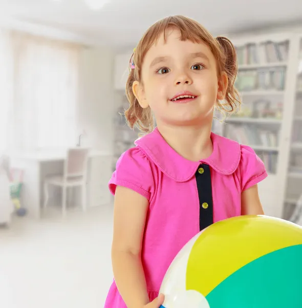 Kleines Mädchen mit gestreiftem Ball — Stockfoto