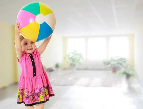 Chica sosteniendo pelota sobre la cabeza — Foto de Stock