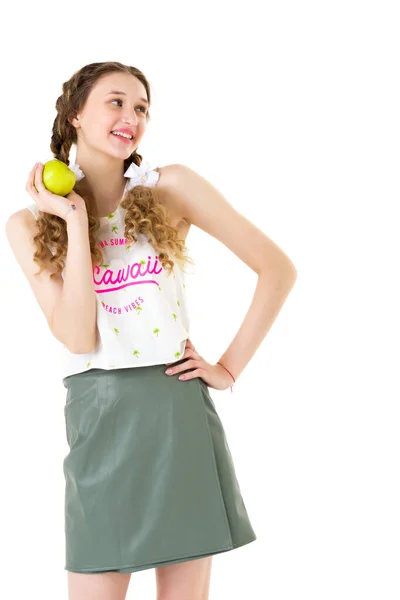 Chica sonriente con dos trenzas sosteniendo manzana verde —  Fotos de Stock