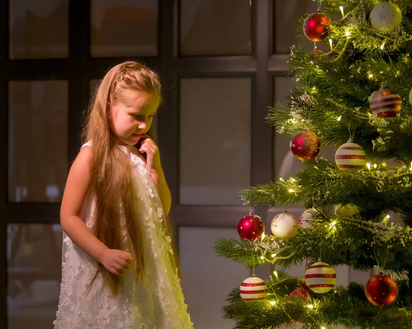 Mała dziewczynka dekoruje choinkę. Koncepcja nowego roku, rodzinne wakacje. — Zdjęcie stockowe