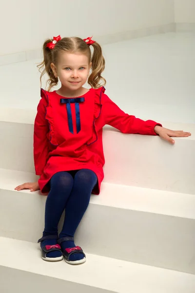 Cute blondynka mała dziewczynka siedzi na schodach — Zdjęcie stockowe