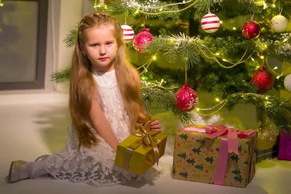 Noel ağacının yanındaki küçük kız hediye getirmiş.. — Stok fotoğraf