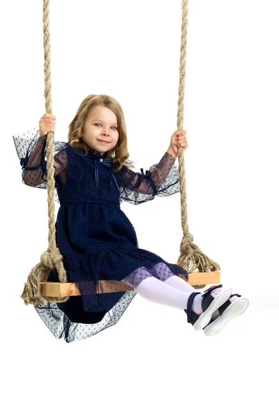 Linda menina loira balançando no balanço da corda Imagem De Stock